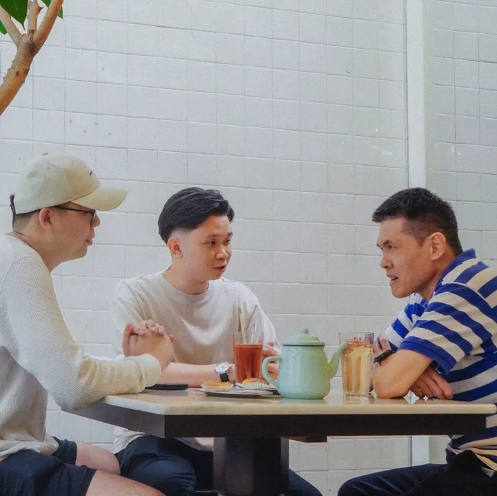 Three friends talking over tea at a cafe table