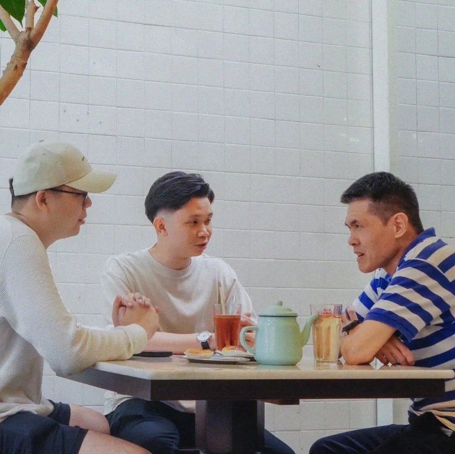 Three friends talking over tea at a cafe table